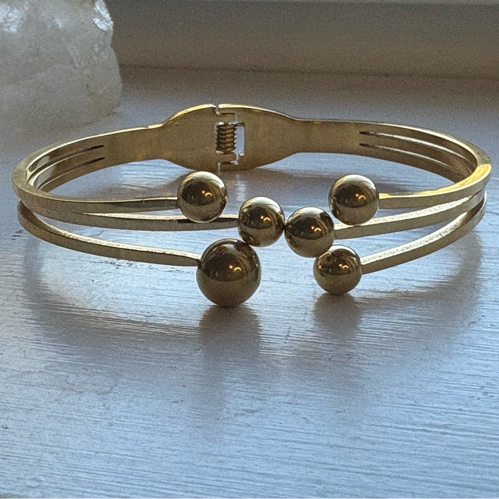 Gold Tone Beaded Bangle. 6 1/2” opens in front of